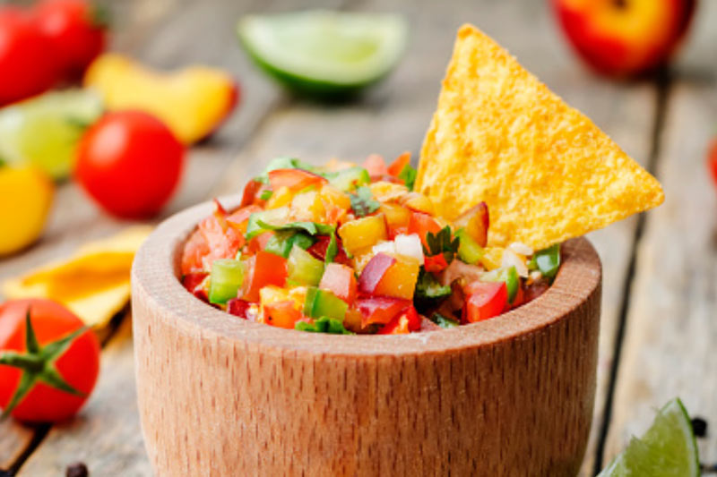 salsa in a wooden bowl with chip